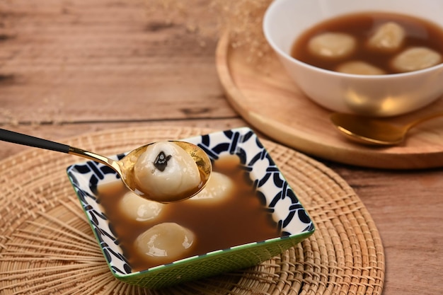 Deliciosos dumplings dulces con sopa de jengibre dulce en la mesa de madera.