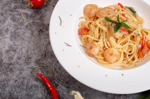 Deliciosos espaguetis con camarones en una mesa de cemento