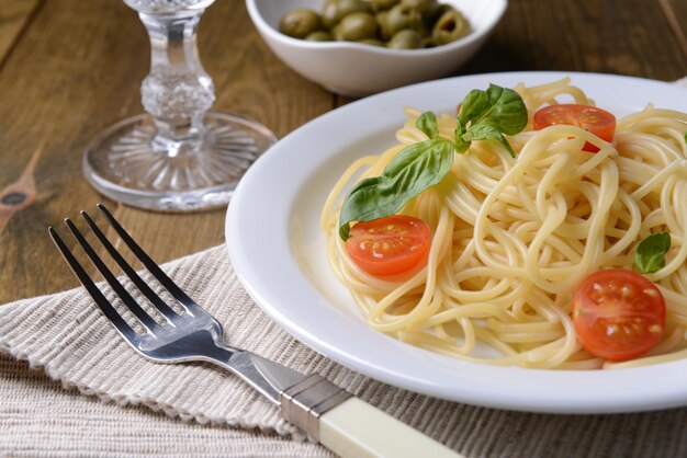 Deliciosos espaguetis con tomates en un plato en el primer plano de la mesa