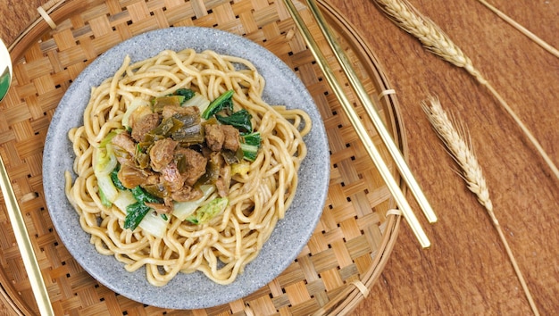 Foto deliciosos fideos de pollo indonesios llamados mie ayam cubiertos con carne de pollo y vegetales verdes fideos populares en indonesia