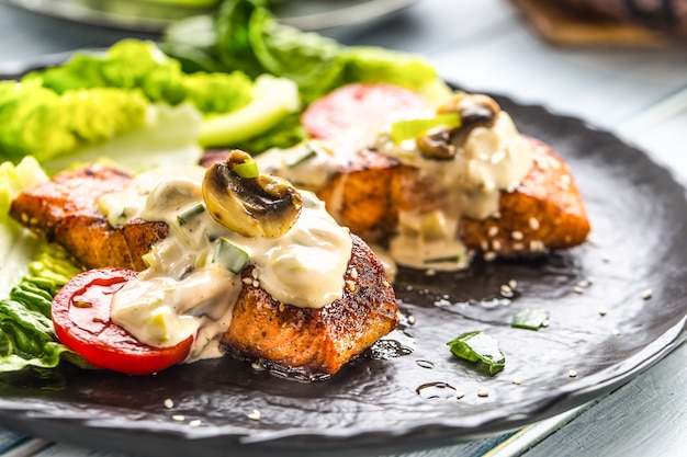 Deliciosos filetes de salmón asado a la plancha o filetes con salsa de champiñones, tomates al ajonjolí y ensalada de lechuga.