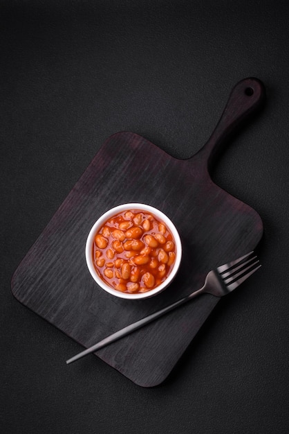 Deliciosos frijoles enlatados en un tomate en un tazón de cerámica blanca