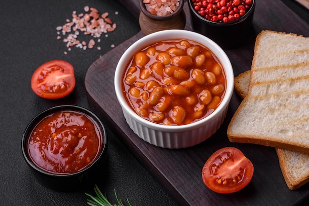 Deliciosos frijoles enlatados en un tomate en un tazón de cerámica blanca