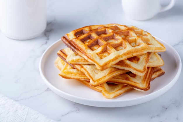 Deliciosos gofres belgas caseros en la mesa blanca