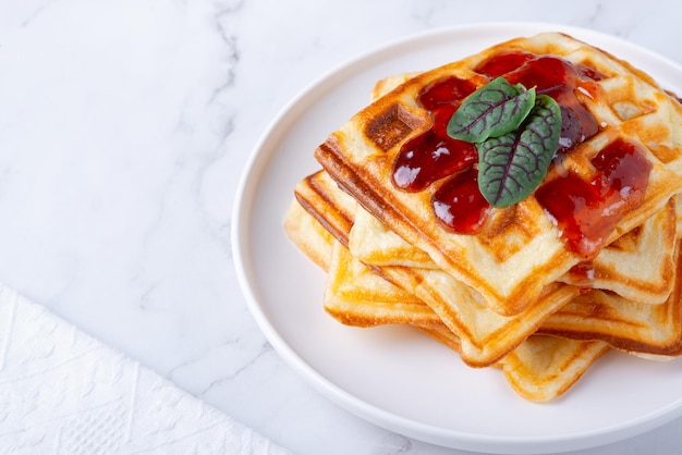 Deliciosos gofres belgas caseros en la mesa blanca