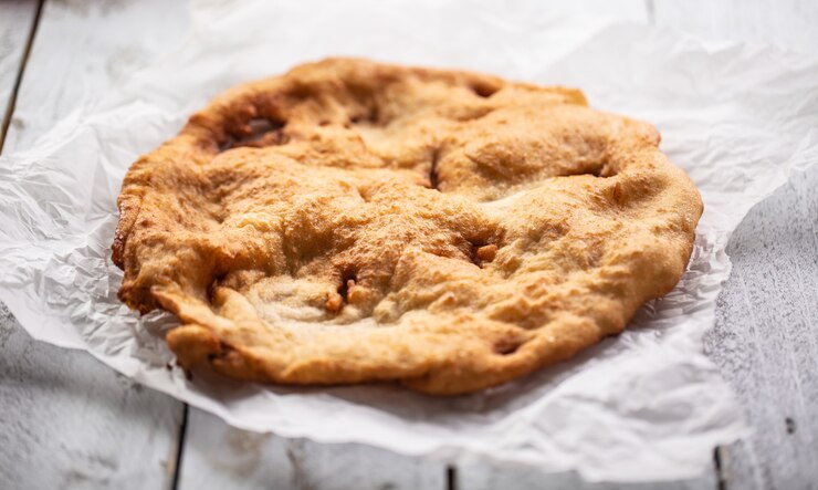 Deliciosos langos horneados y fritos tradicionales húngaros servidos en un papel.