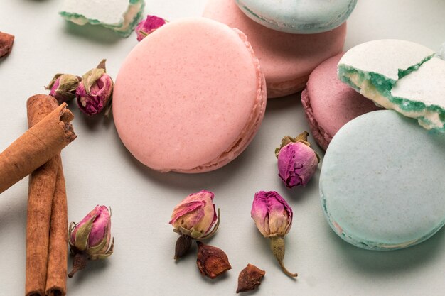 Deliciosos macarrones de galletas de colores con flores color de rosa.