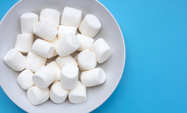 Deliciosos malvaviscos blancos sobre fondo azul.