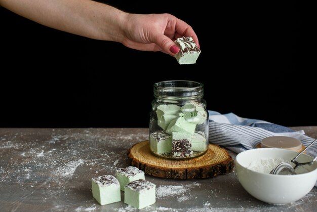 Foto deliciosos marshmallows de menta são dobrados em uma jarra de vidro.