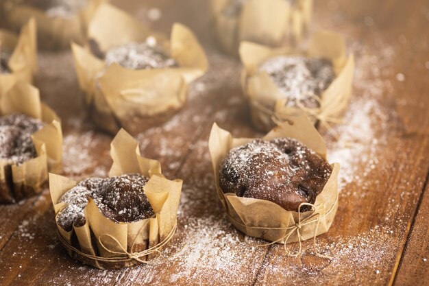 Deliciosos muffins de chocolate con azúcar en polvo sobre la mesa