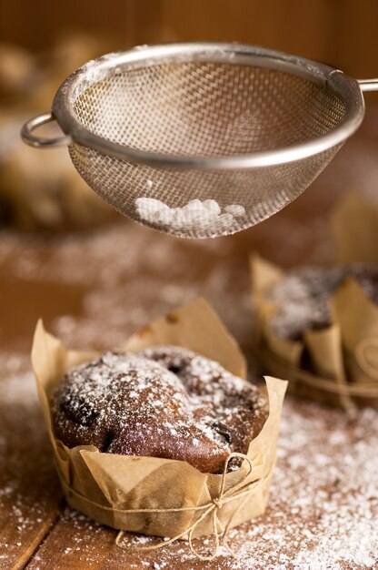 Deliciosos muffins de chocolate con azúcar en polvo sobre la mesa