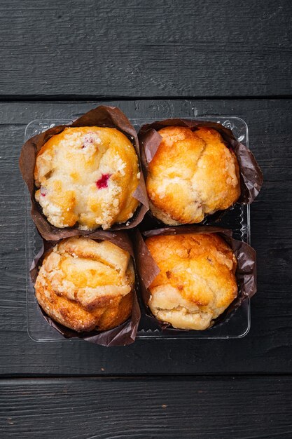 Deliciosos muffins sabrosos, sobre fondo de mesa de madera negra, vista superior plana