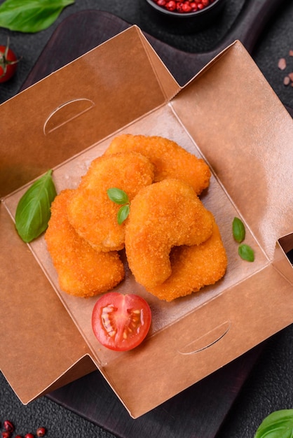 Deliciosos nuggets de frango crocantes e frescos sobre um fundo escuro de concreto Fast food pouco saudável