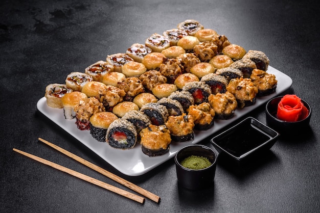 Deliciosos panecillos frescos en varios juegos. Comida japonesa con aguacate, camarones, cangrejo y salmón