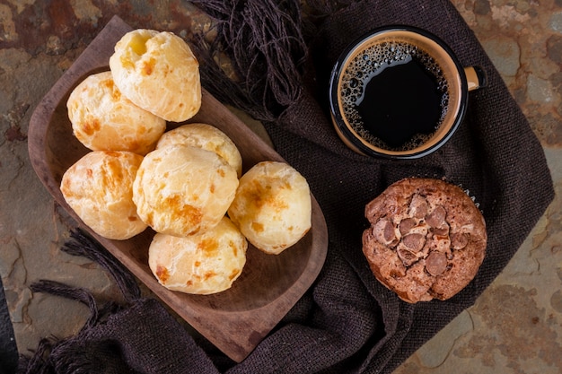 Deliciosos panes de queso, muffins de chocolate y una taza de café.