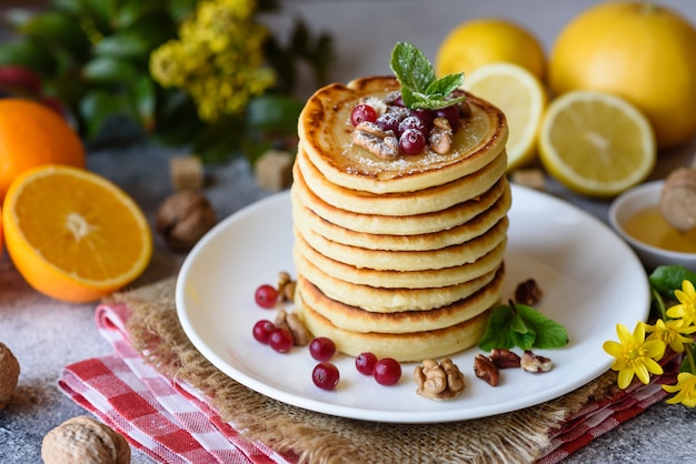 Deliciosos panqueques frescos hermosos con miel de cítricos y mermelada. Delicioso desayuno caliente con panqueques con frutas y bayas