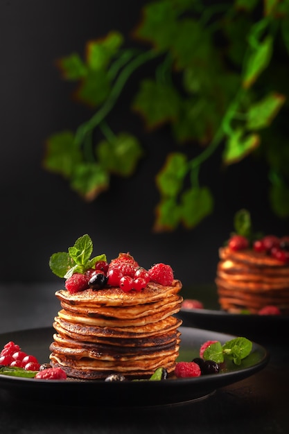 Deliciosos panqueques horneados con frutas frescas de frambuesas, grosellas y fresas