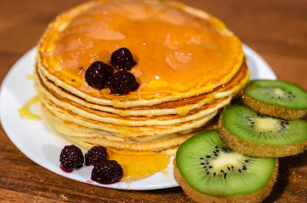 Deliciosos panqueques con miel, kiwi y bayas.