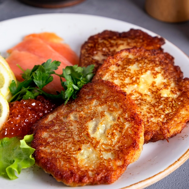 Foto deliciosos panqueques de patata con caviar y salmón en un plato primer plano