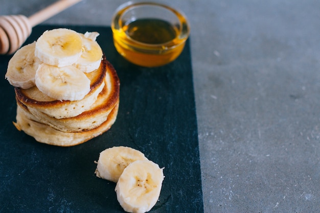 Deliciosos panqueques con plátano y miel en un desayuno