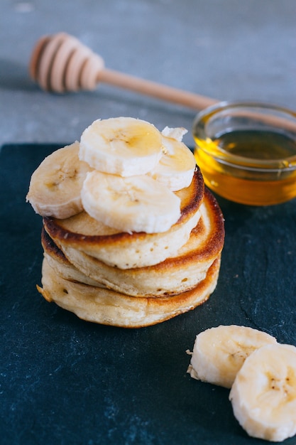 Deliciosos panqueques con plátano y miel en un desayuno