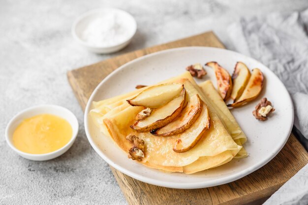 Deliciosos panqueques recién horneados con miel y frutas sobre un fondo de hormigón texturizado Comida saludable útil