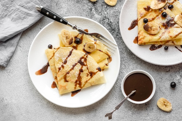 Deliciosos panqueques recién horneados con miel y frutas sobre un fondo de hormigón