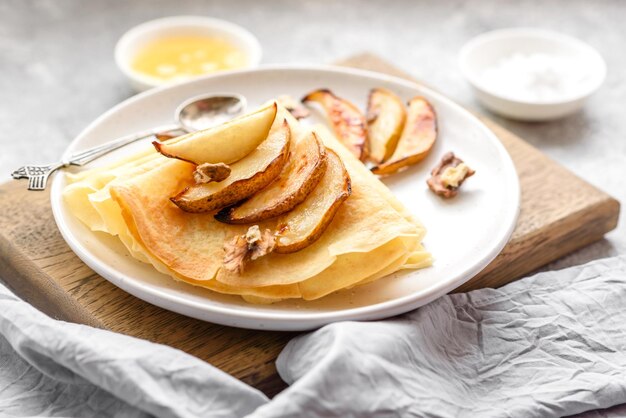 Deliciosos panqueques recién horneados con miel y frutas sobre un fondo de hormigón