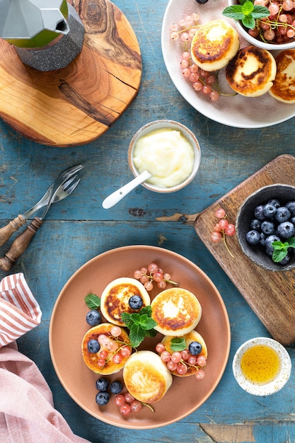 Deliciosos panqueques de requesón se sirven con miel y bayas Platos de la cocina rusa ucraniana