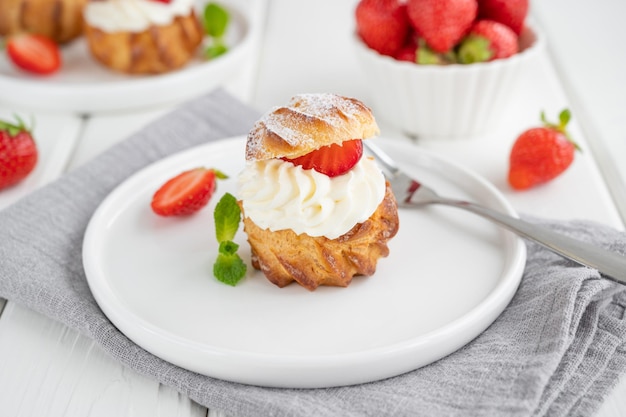 Deliciosos pasteles caseros de hojaldre de profiteroles con crema pastelera de fresa. Copiar espacio.