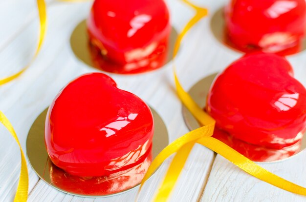 Deliciosos pasteles en forma de corazones rojos brillantes.