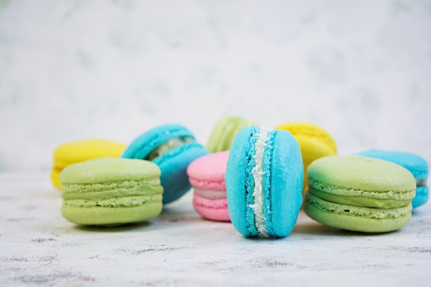 Deliciosos pasteles macaron coloridos en madera