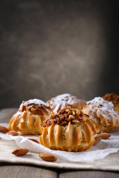 Deliciosos pasteles en la mesa sobre fondo gris