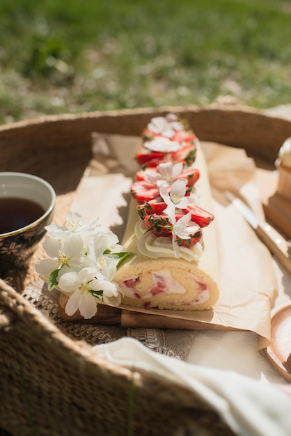 Deliciosos pasteles en un picnic en el parque, decorados con fresas en una canasta