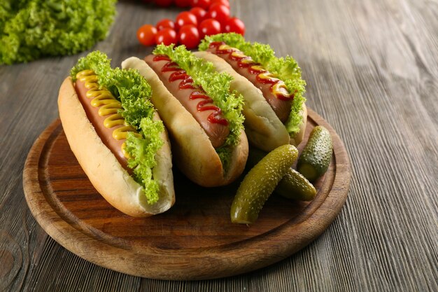 Foto deliciosos perritos calientes con verduras en la mesa de madera