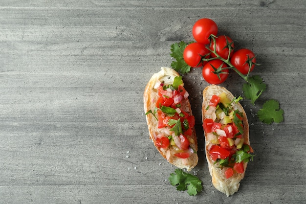 Deliciosos petiscos de bruschetta em fundo cinza texturizado