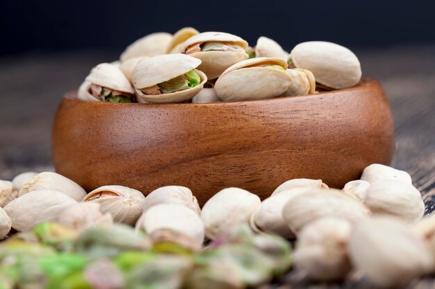 Deliciosos pistachos salados fritos, pistachos en una mesa de madera durante la cocción