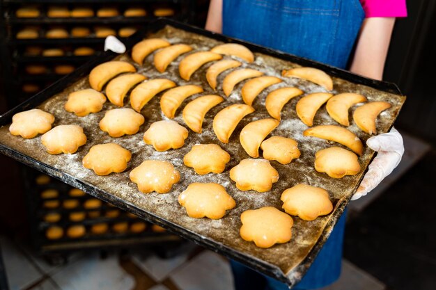 Deliciosos postres de panadería en las manos. Hembra joven que trabaja con panadería industrial.