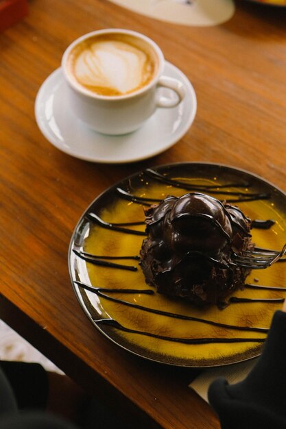 Deliciosos profiteroles con chocolate en la mesa