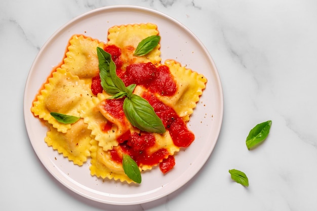 Deliciosos ravioles apetitosos con salsa de tomate y albahaca Vista superior