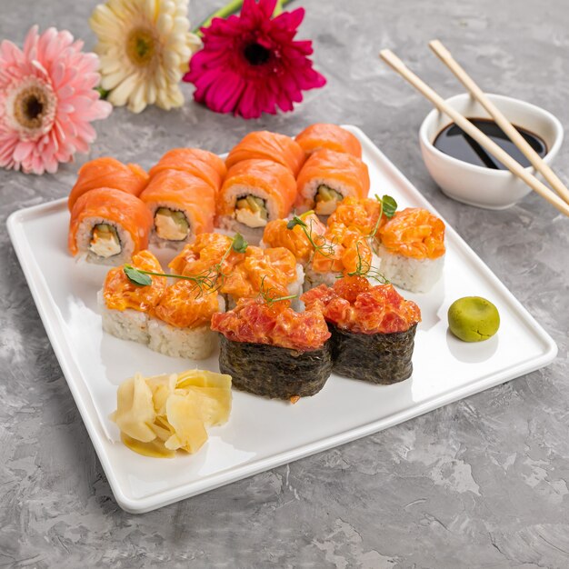 Deliciosos rollos japoneses en una placa blanca.