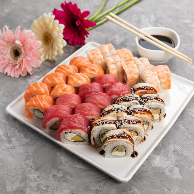 Deliciosos rollos japoneses en una placa blanca.