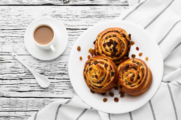 Deliciosos rollos de pasas de canela en la mesa de madera