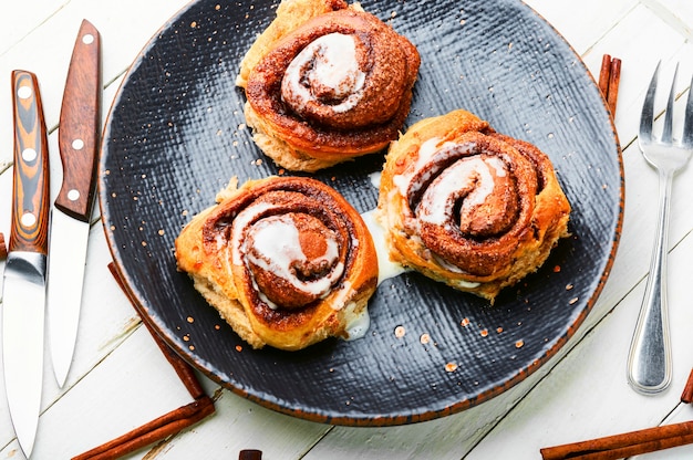 Deliciosos rolos de canela. Cannabons caseiros num prato. Pãezinhos apetitosos