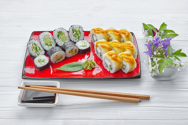 Deliciosos rolos de sushi com wasabi e gengibre com pauzinhos