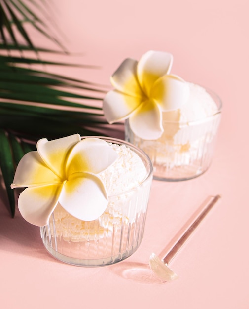 Deliciosos sabores tropicais sorvete sorbet sundae decorado flor plumeria frangipani e folha de palmeira no fundo Conceito de comida de verão