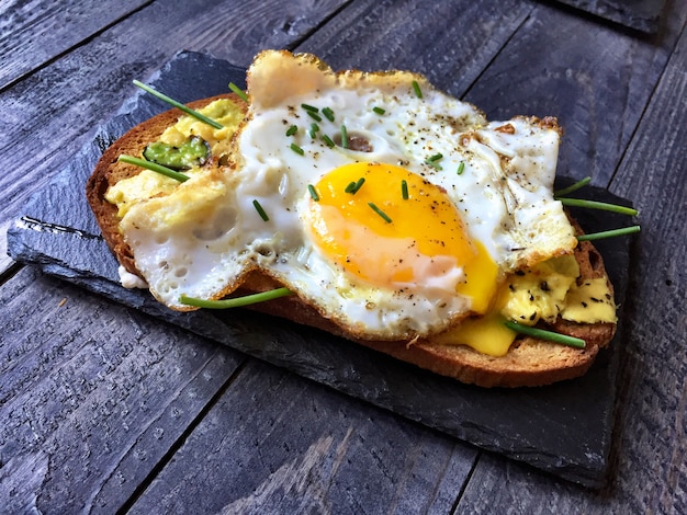 Deliciosos sabrosos huevos de aguacate y tostadas de queso con tomate