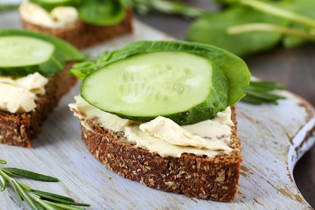 Deliciosos sanduíches com legumes e verduras na tábua de cortar