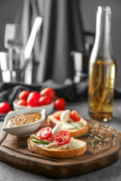 Deliciosos sanduíches com tomate cereja e mussarela na placa de madeira