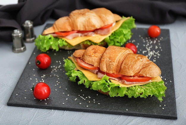 Deliciosos sanduíches de croissant na placa de ardósia